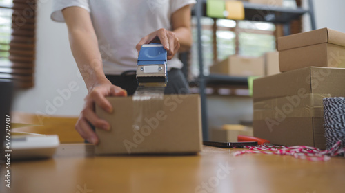 Business owner entrepreneur packing cardboard box preparing parcel for shipment, Online marketing.