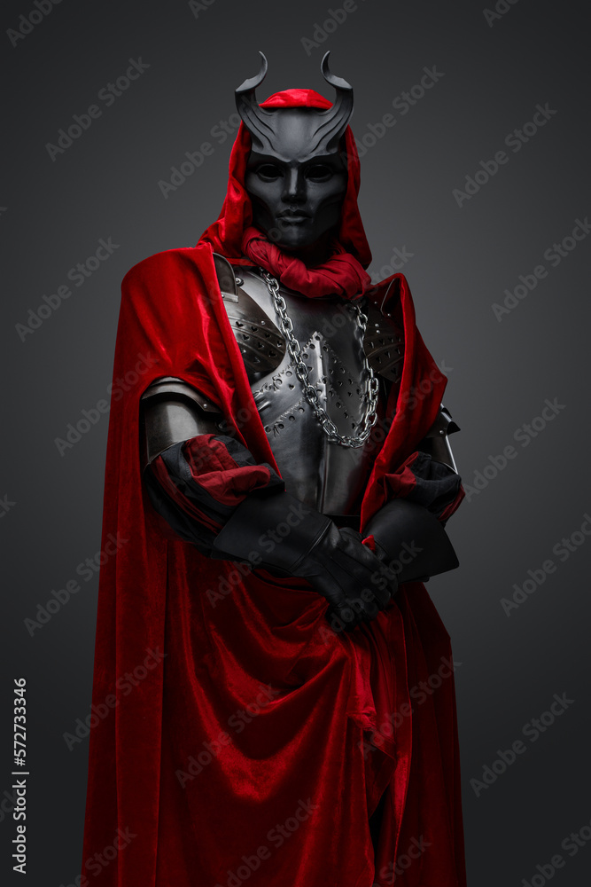 Portrait of dark knight with red robe and black mask isolated on gray background. Portrait of dark knight with red robe and black mask isolated on gray background.