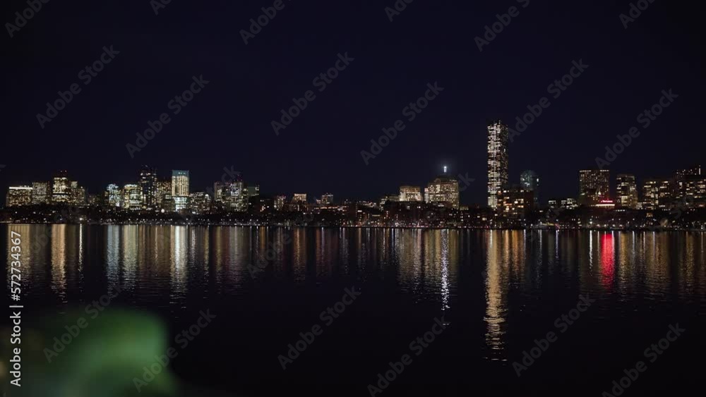 Boston, MA skyscrapers, business traffic, and lights during a blue, dark night from an aerial and establishing drone shot perspective Boston, MA skyscrapers, business traffic, and lights during a blue, dark night from an aerial and establishing drone shot perspective