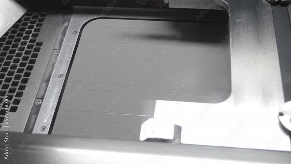 Alignment of metal powder on working surface of 3D printer for metal before starting work. Gray material metal powder for printing objects by 3d printer for metal. Working 3d printer inside. Alignment of metal powder on working surface of 3D printer for metal before starting work. Gray material metal powder for printing objects by 3d printer for metal. Working 3d printer inside.