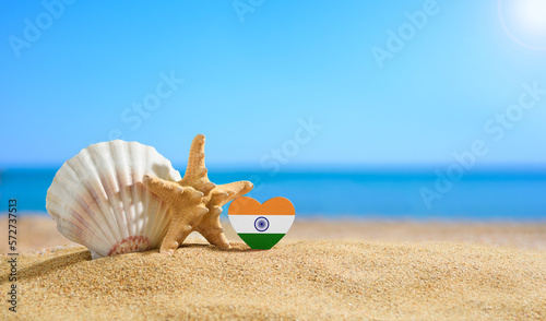 Beautiful beach in India. Flag of India in the shape of a heart and shells on a sandy beach.