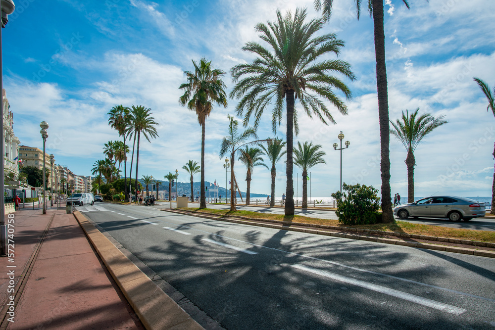 Amazing  Promenade des Anglais   with fantastic palm trees and walking people ( or by bicycle)  in Nice, French Riviera