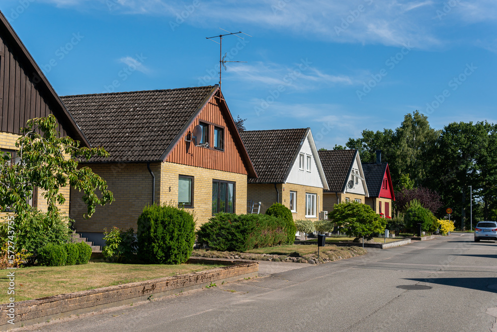 Naklejka premium Sweden, Knislinge – July 30, 2022: Beautiful private houses along the street on a sunny summer day. European architecture, modern village. Cottage house, dacha. Cozy place for living. Real estate. 