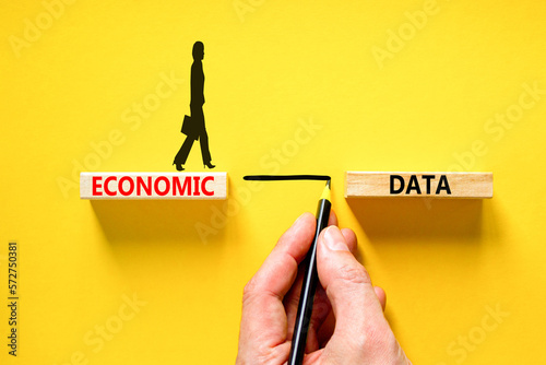 Economic data symbol. Concept words Economic data on wooden block. Beautiful yellow table yellow background. Businessman hand. Businessman icon. Business economic data concept. Copy space.