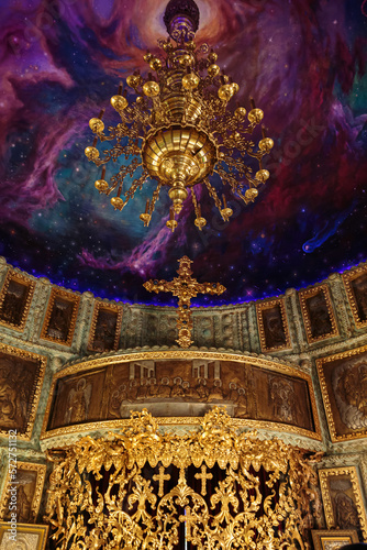 Part of the interior of old traditional orthodox church. Painted ceiling with a beautiful golden chandelier in Orthodox Church