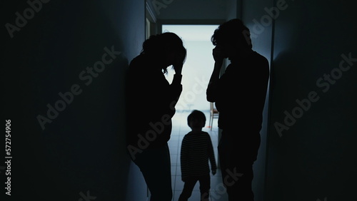 Silhouette of couple standing in corridor in crisis. Parents with child feeling worry and anxiety. Husband and wife discussing difficult situation