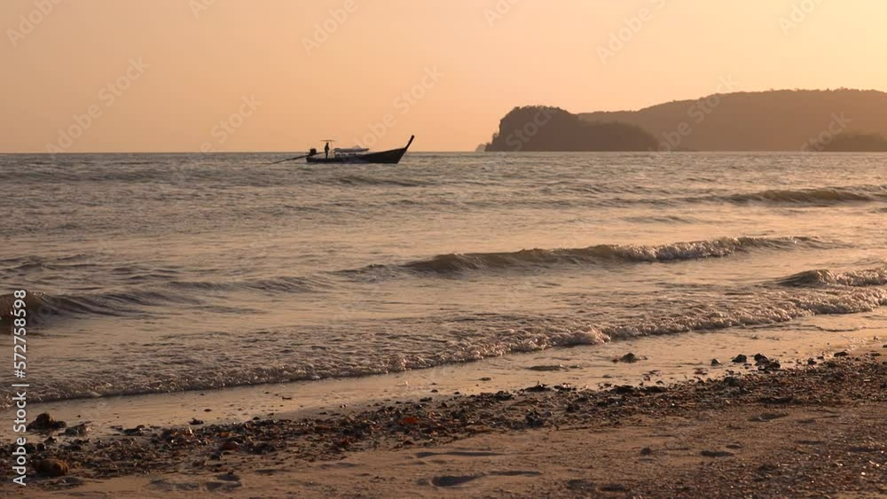 Golden sunset over on the beach - slow motion of foaming waves. and passenger ships.