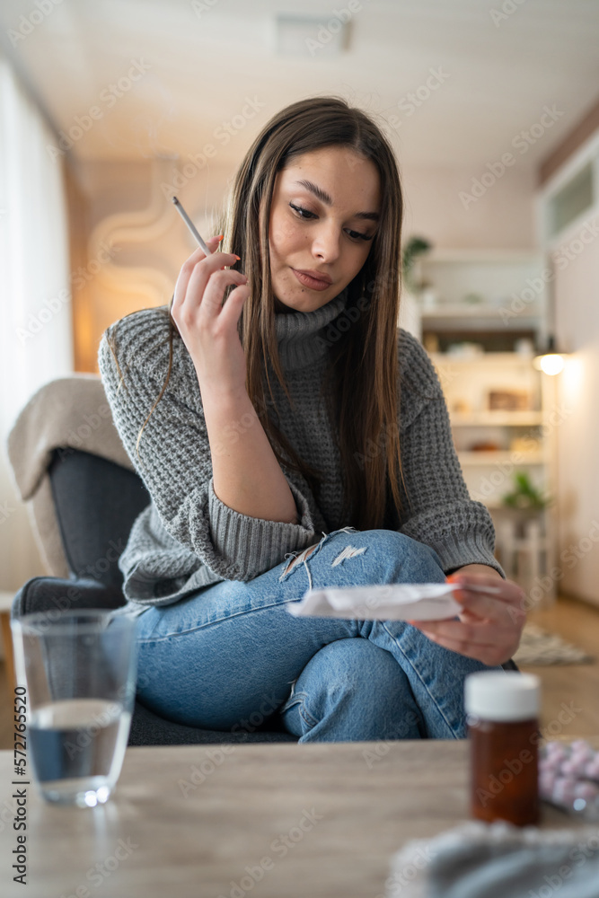 Fototapeta premium One woman young caucasian female sit at home smoke cigarette read note