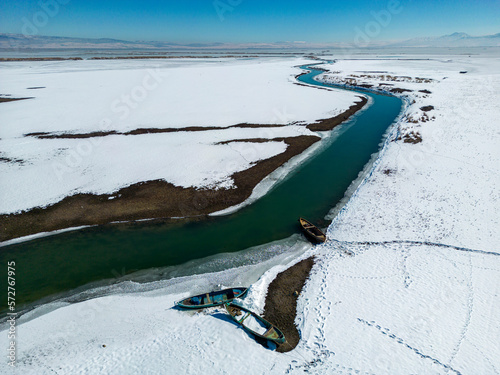 fishing boats await thawing by the frozen lake