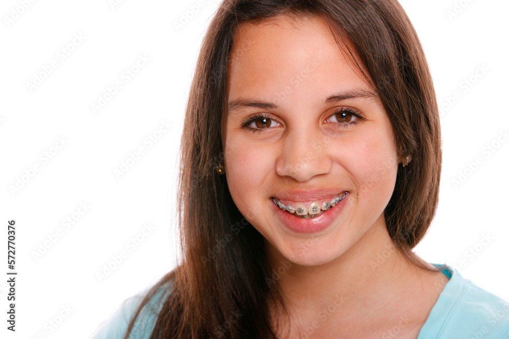 Studio portrait of teenage girl wearing braces and smiling in front of white background. Studio portrait of teenage girl wearing braces and smiling in front of white background.