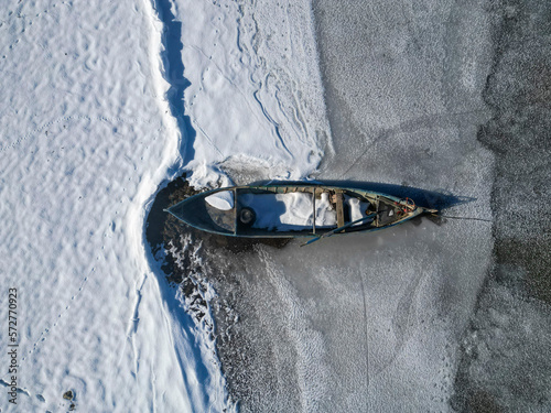 fishing boats await thawing by the frozen lake