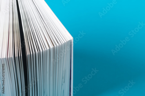 Open white book on a turquoise background photo