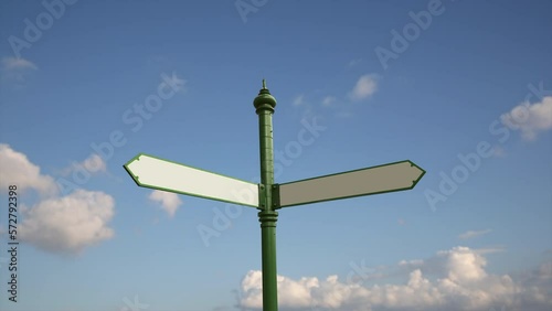 Blank directional forked road sign over sunny blue sky