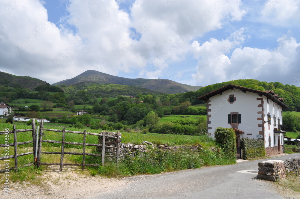 Paisaje rústico desde carretera con una casa de pueblo al lado de