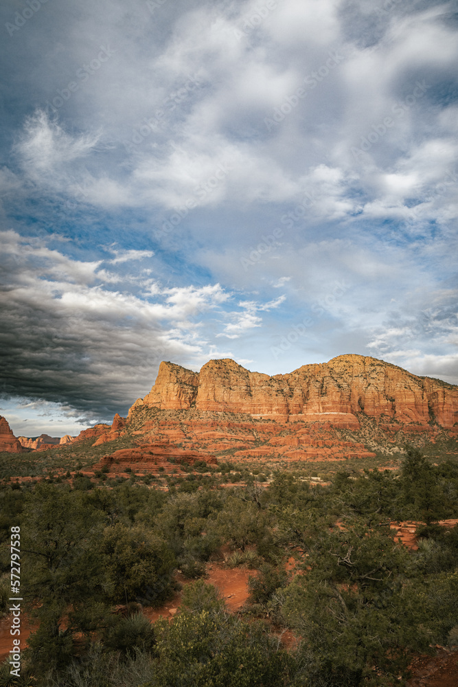 Sunset view of red rock buttes and formations within coconino national forest in Sedona Arizona USA against white cloud background. Horizontal Image.