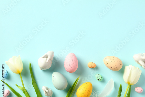 Easter eggs and tulips on pastel blue background. Happy Easter concept. Flat lay, top view.