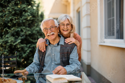 Schilderij op canvas Happy senior woman and her husband on patio at nursing home looking at camera