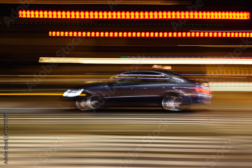 blurred image of a driving car on a city street at night