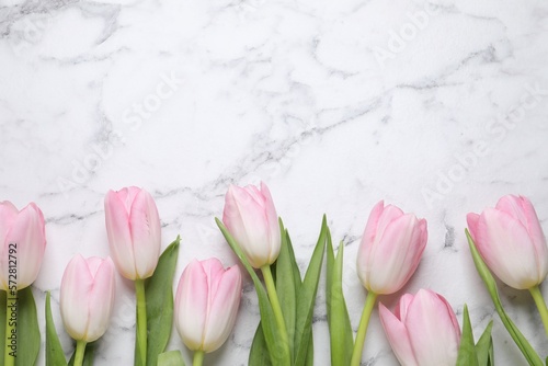 Fototapeta Naklejka Na Ścianę i Meble -  Beautiful tulips  on white marble table, flat lay. Space for text