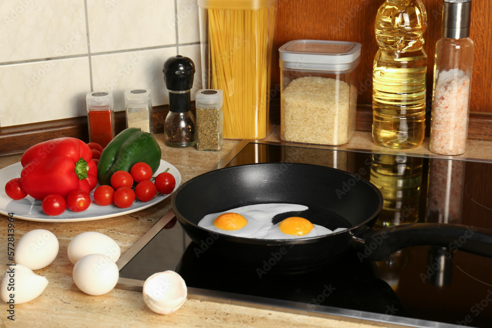 Cooking eggs for breakfast in frying pan on cooktop Cooking eggs for breakfast in frying pan on cooktop