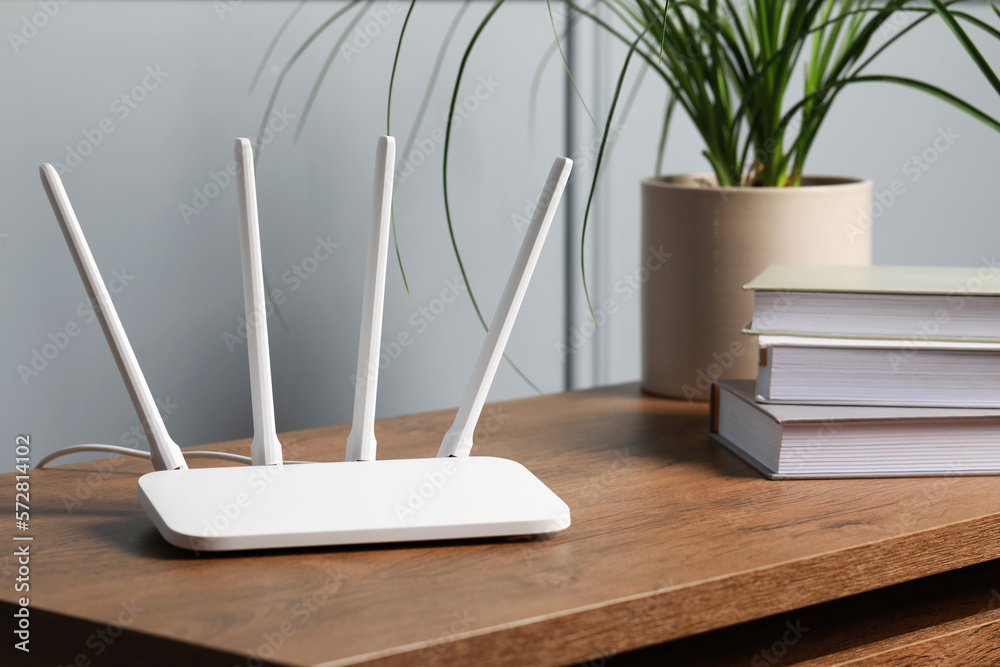 New white Wi-Fi router on wooden table indoors - obrazy, fototapety, plakaty 