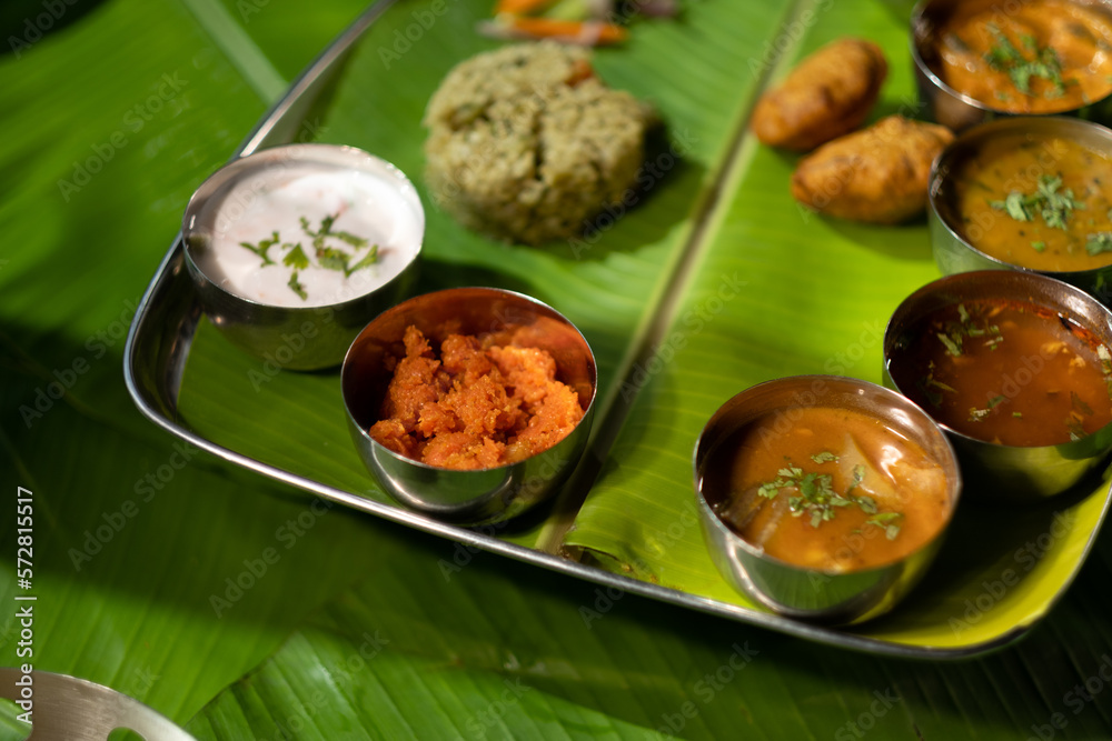 Served south Indian style, a meal plate has chutney, sauce, rice, fried potato dumplings, and other tasty bites.