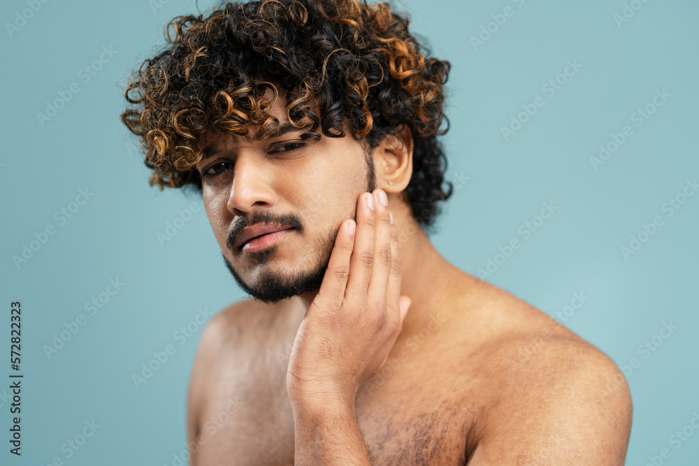 Attractive Hindu man with perfect skin, touch face after shaving, poses
