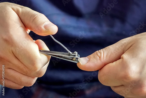 Man hands using nail clipper for fingernails manicure. self-cutting nails.