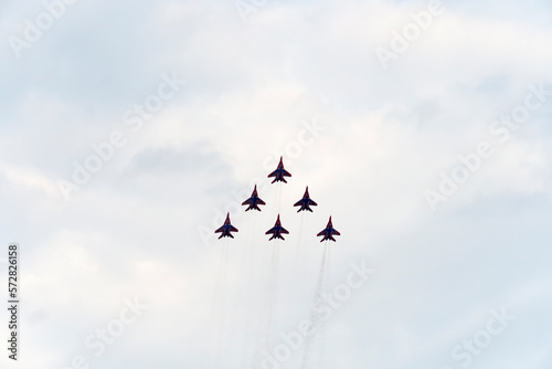 group of Russian military aircraft shows aerobatics in the blue sky against the background of clouds. photo