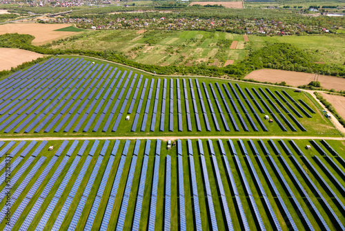 Aerial view of big sustainable electric power plant with many rows of solar photovoltaic panels for producing clean ecological electrical energy. Renewable electricity with zero emission concept