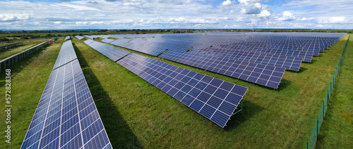 Aerial view of big sustainable electric power plant with many rows of solar photovoltaic panels for producing clean electrical energy. Renewable electricity with zero emission concept