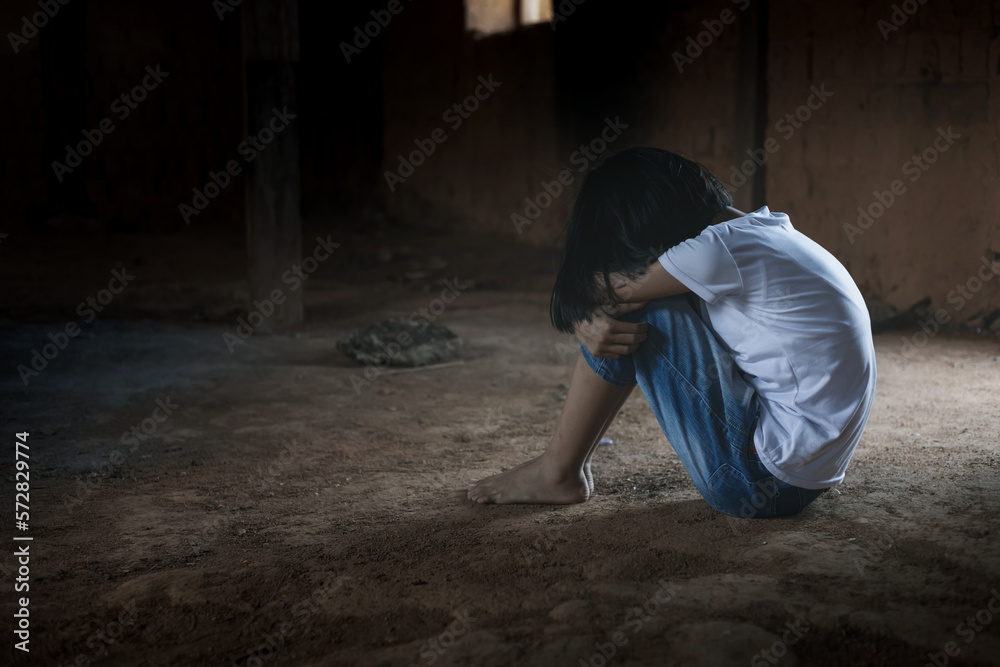 Sad child girl sitting alone with sad feeling at old room. Human trafficking