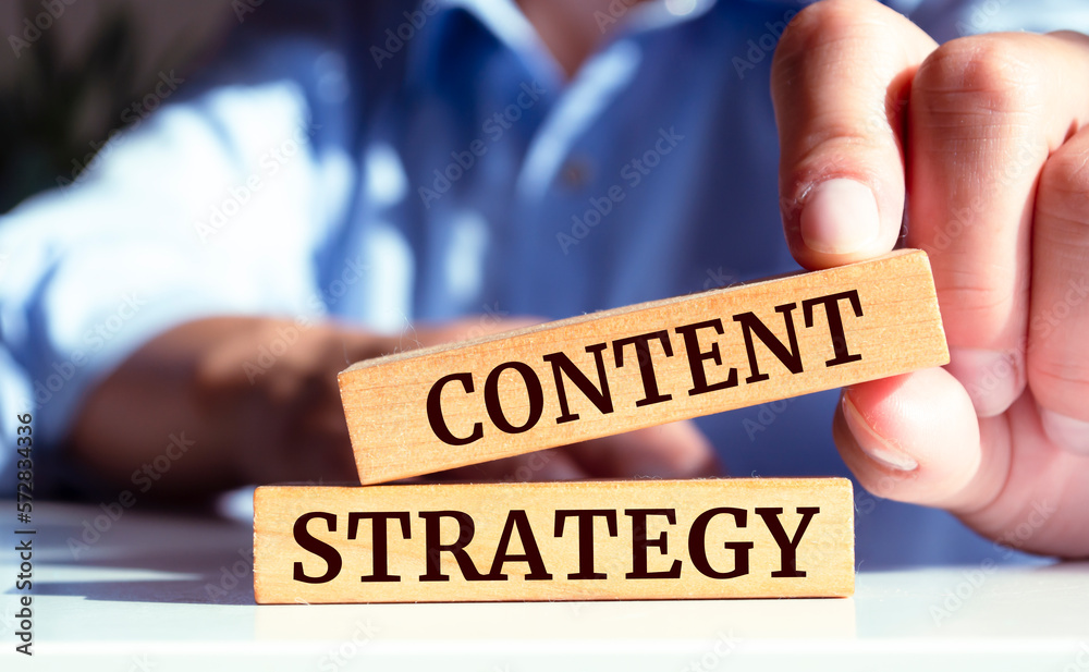 Closeup on businessman holding a wooden block with Content strategy message, business concept Closeup on businessman holding a wooden block with Content strategy message, business concept