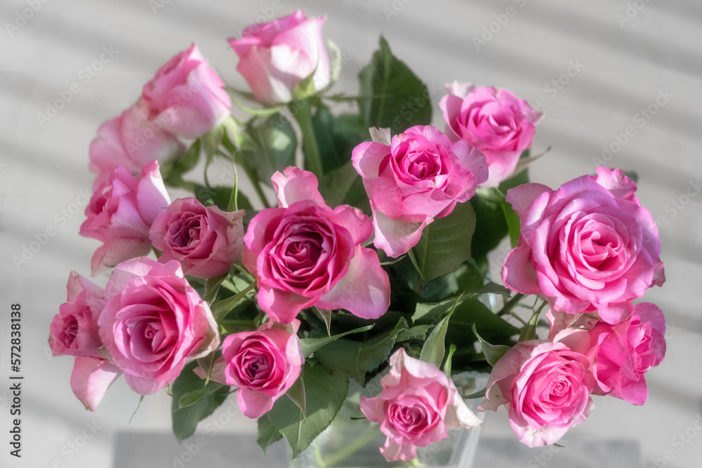 The photo shows a bouquet of pink roses in a vase The photo shows a bouquet of pink roses in a vase