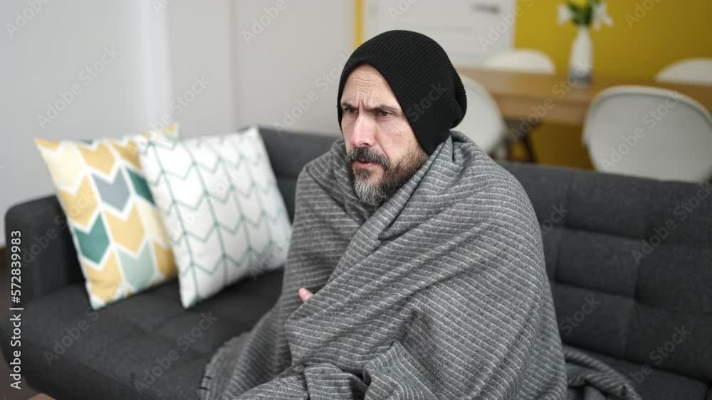 Young bald man covering with blanket for cold at home Young bald man covering with blanket for cold at home