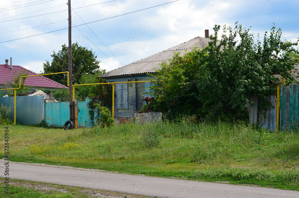 an old house with a well near the road.Russian village.