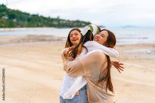 Group of Young Asian woman friends walking and playing together on tropical island beach at summer sunset. Attractive girl enjoy and fun outdoor lifestyle travel on beach holiday vacation at the sea.