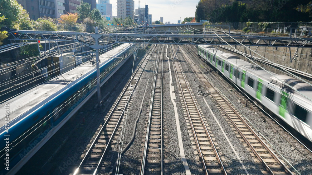 Naklejka premium High angle view landscape of Trains running on railway track arrival and departure from railway station platform in Tokyo city , Japan. Urban transportation and rail industry concept.