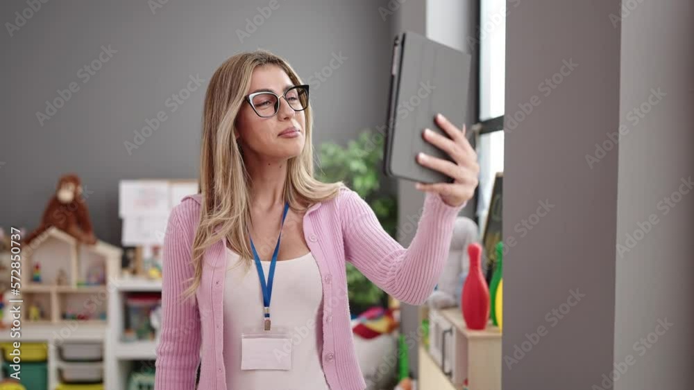 Young blonde woman teacher smiling confident having video call at kindergarten Young blonde woman teacher smiling confident having video call at kindergarten