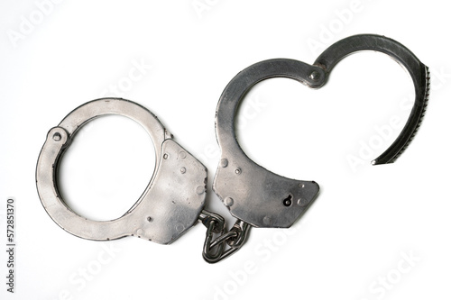 The object is a steel single sided handcuff locked on a white background, symbolizing law, crime and love.