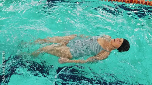 A healthy elderly woman in a swimsuit swimming in a pool active retirement concept. High-quality 4k footage