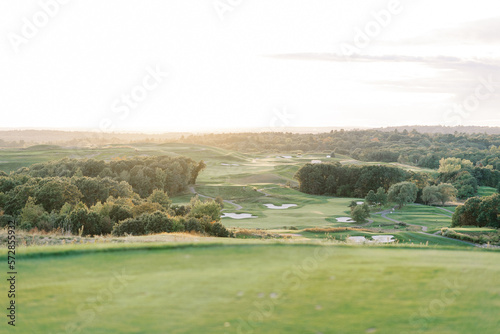 golden sunset light over a well manicured lush green golf course photo