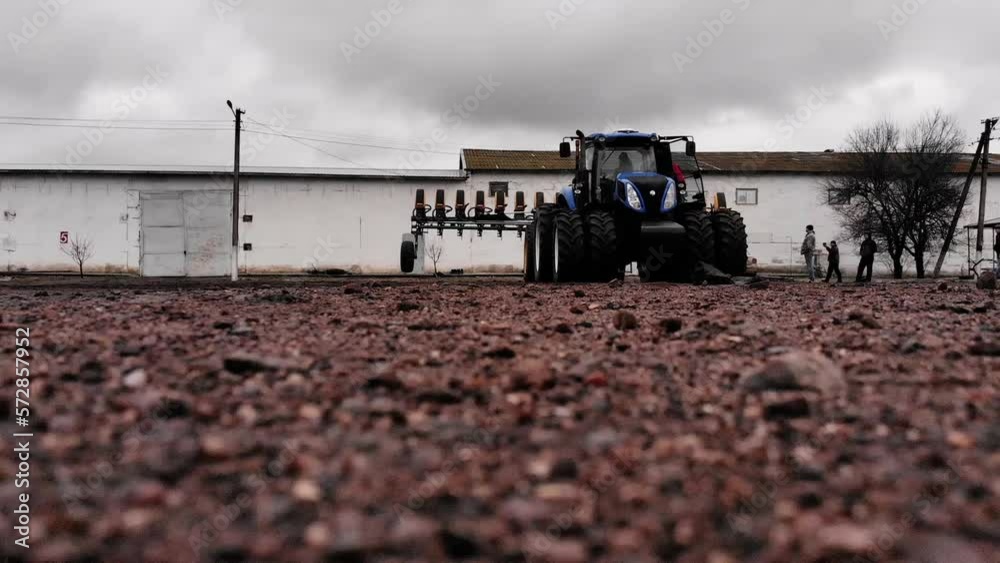 Blue tractor with new planter at the farm before the planting season in Ukraine Blue tractor with new planter at the farm before the planting season in Ukraine