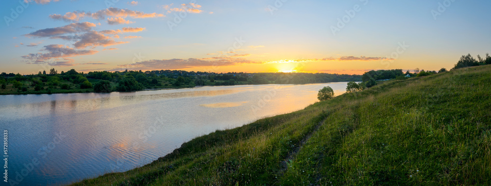 Summer panoramic rural landscape with green hills and blue calm river.Beautiful clouds in colorful sunrise sky over the land. Summer panoramic rural landscape with green hills and blue calm river.Beautiful clouds in colorful sunrise sky over the land.