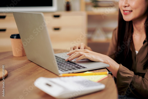 Female entrepreneur reading new business project and typing data