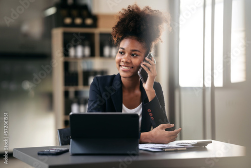 African american businesswoman in suit looking outside and talki photo
