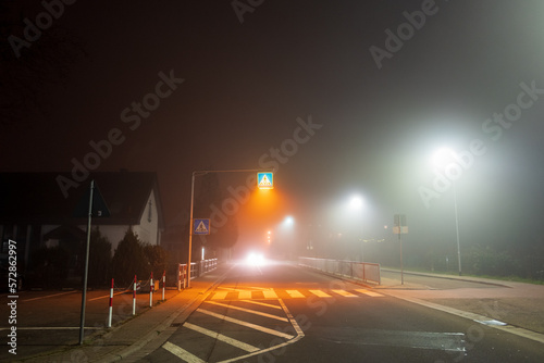 night traffic in the city with thick fog and an approaching car