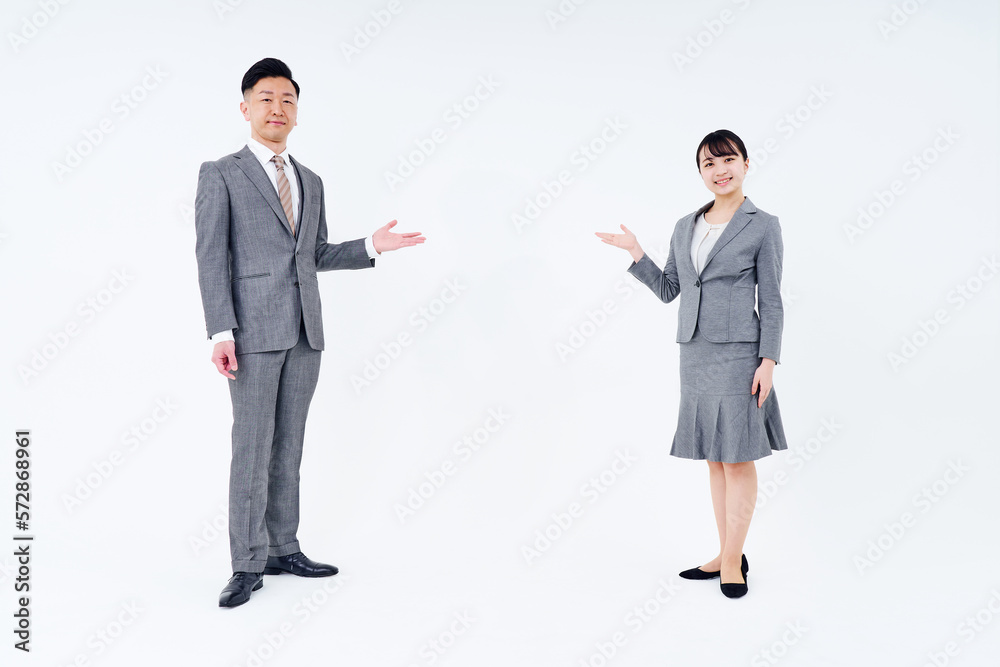 案内のポーズをするスーツ姿の男女 案内のポーズをするスーツ姿の男女