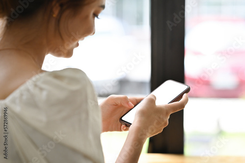 Rear view image of Young Caucasian teenage girl using smartphone, Empty screen of device.