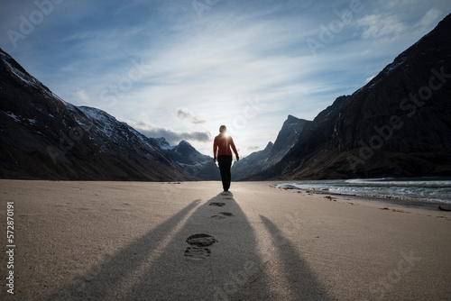 Female hiker leaves footprints in sand on scenic Horseid beach, MoskenesÃ¸y, Lofoten Islands, Norway